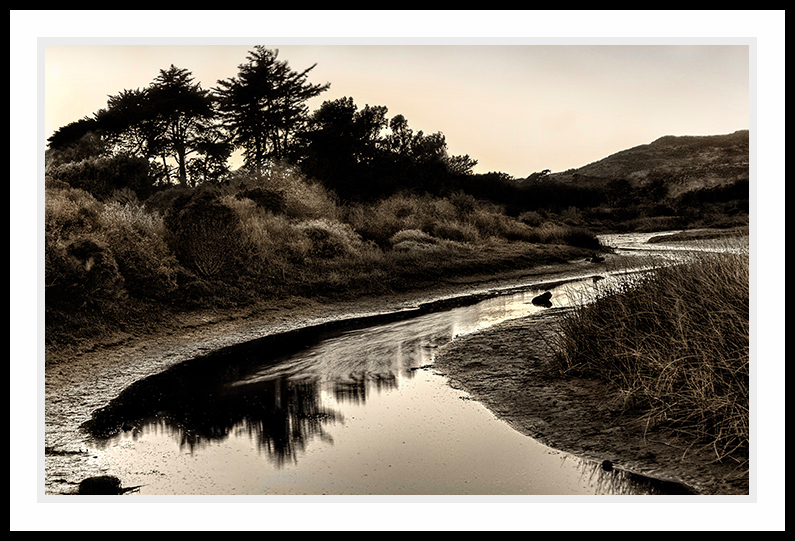 Water flowing through a field in Sepia tones.